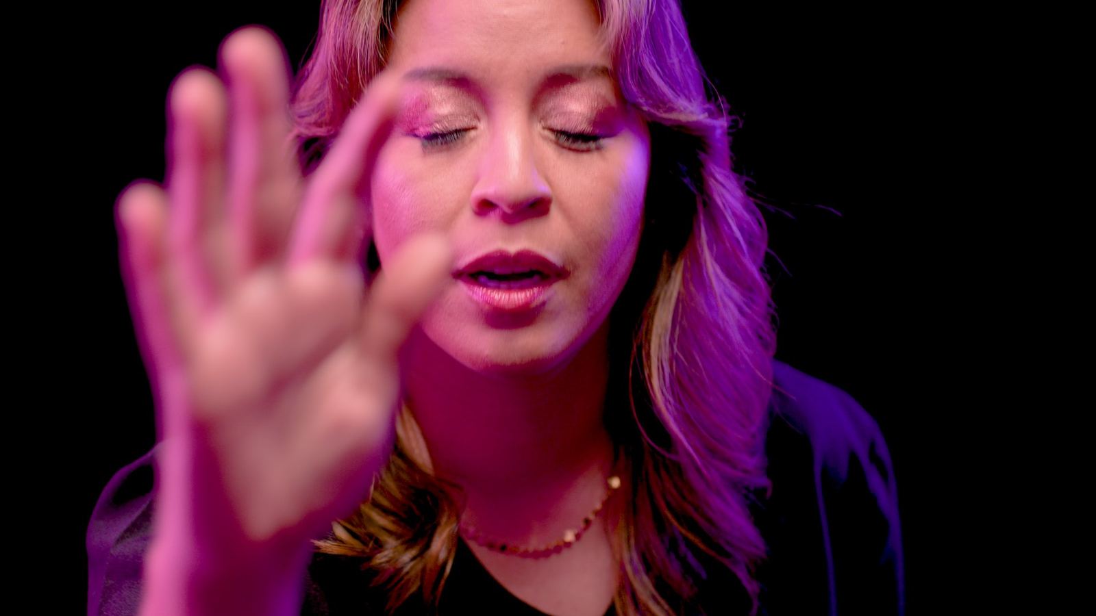 Maggie raises her hand in a still from the short film Maggie Magic Fingers